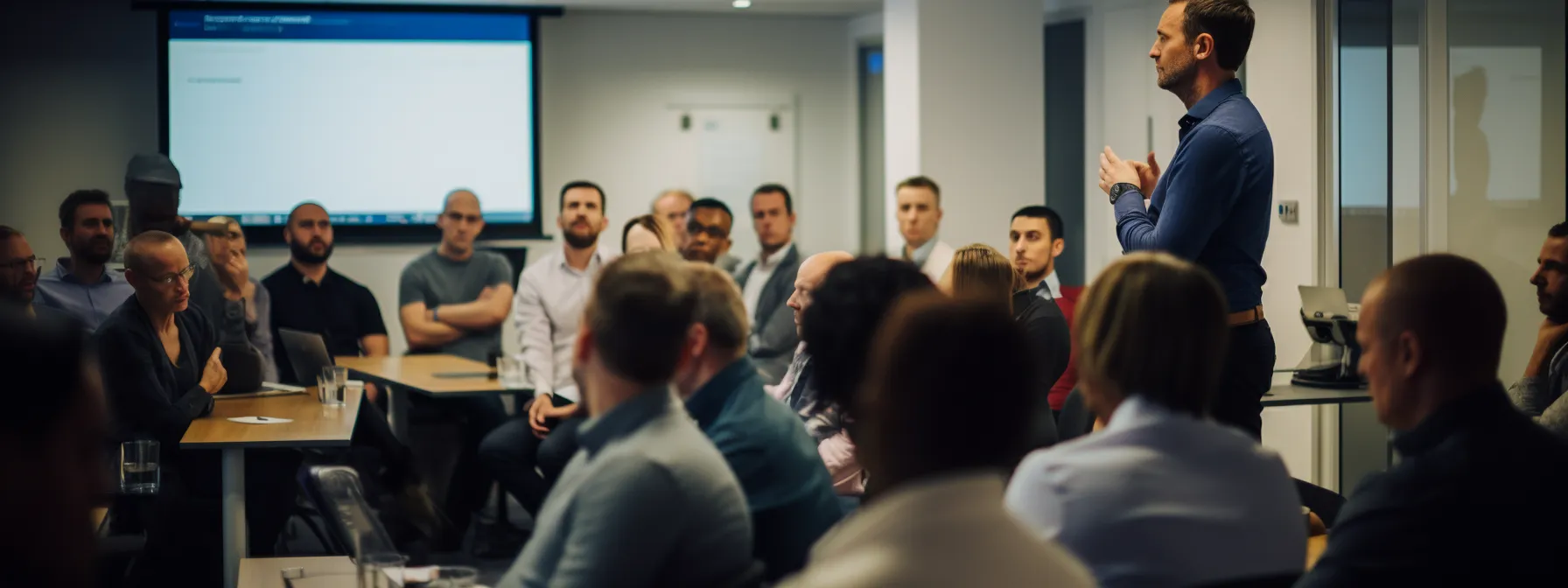 a group of people in a training room, listening attentively to a presenter discussing seo strategies and techniques.